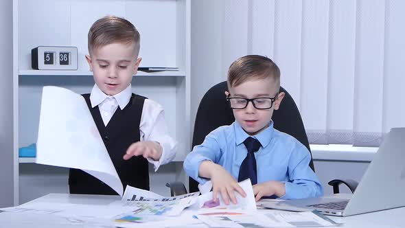 Two Little Boys Looking Graphics and Scatter on the Table. Slow Motion