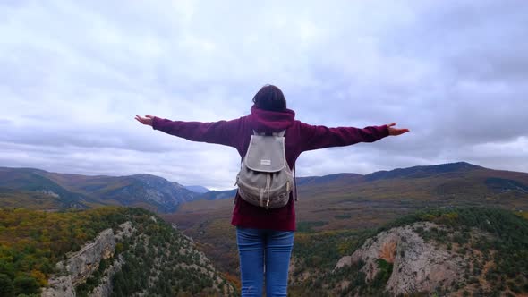 Hipster Woman with Backpack Walking at the Autumn Mountains Nature