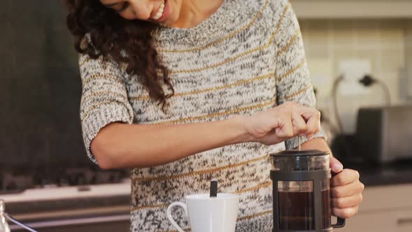 Happy woman wearing winter cloths preparing coffee 4K 4k