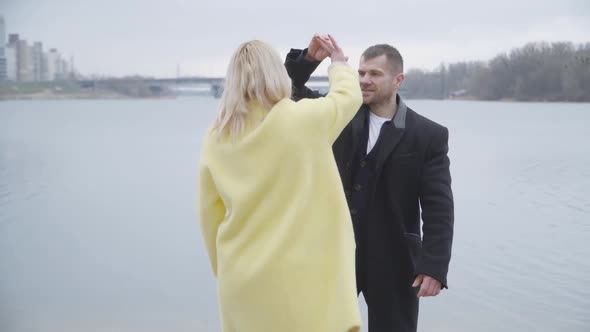 Happy Adult Couple Dancing and Hugging on Riverbank