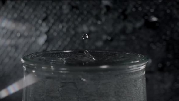 Focused Shot of Full Glass of Water and Droplet Falling