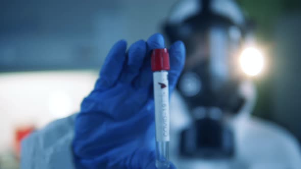 A Doctor in Chemical Protection Suit Holds a Sample of Negative Coronavirus Result.