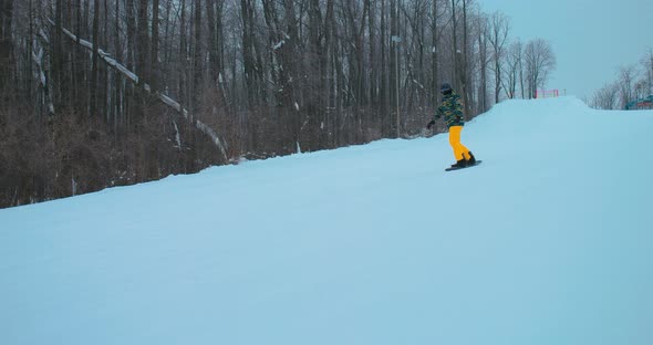 Professional Snowboarder Descends From a Snowy Slope