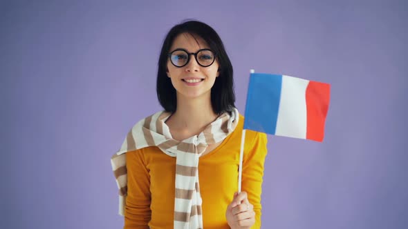 Slow Motion of Cute Young Brunette in Glasses Holding French Flag Smiling