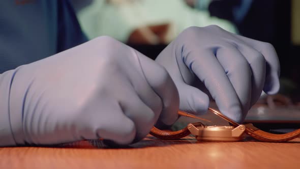 Side View of Watch Repairer Removing Back Case of Watch to Examine Watch Mechanism