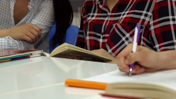 Male Hand Writes in Notebook at the Library