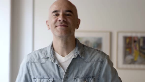 Front View of Handsome Serious Bald Man Posing at Home