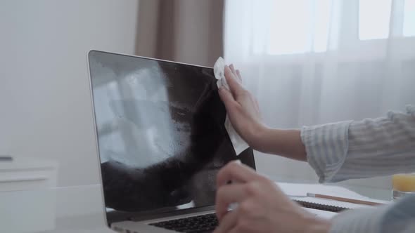 Close Up of Executive Woman Hands Cleaning Laptop with Sanitizer on a Desk