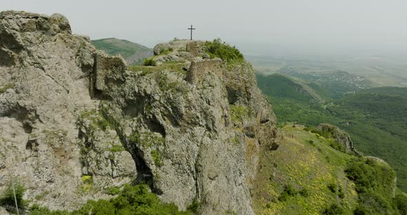 Aerial dolly in shot of a Christian cross on top of the Azeula fortress.