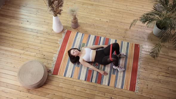 Top View of a Young Woman Exercising on a Wooden Floor