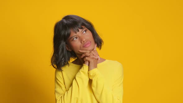 Pensive Woman Keeps Hands Under Chin and Thinks About Something Pleasant