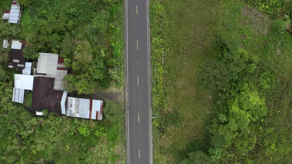 Aerial top view of a one lane highway running through farmland