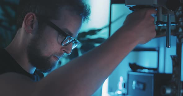 Young Man examines filmstrip with kinetiscope