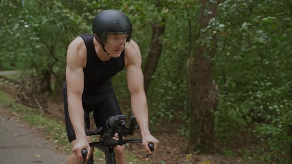 Super Slow Motion Triathlete Rides a Bike Pro Cyclist Rides on a Forest Road Preparation for