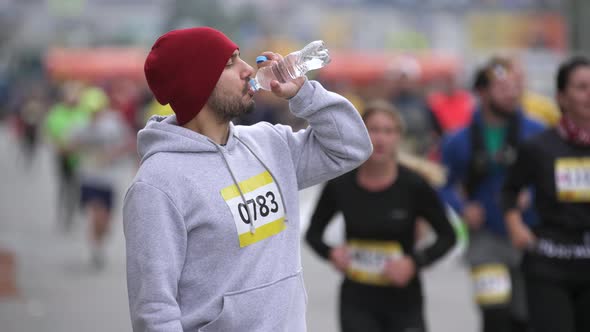 Portrait of Drinking Water and Looking at Camera Sportsman on Marathon Event