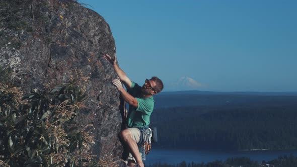 Man Rock Climbing With Mt Rainier Background