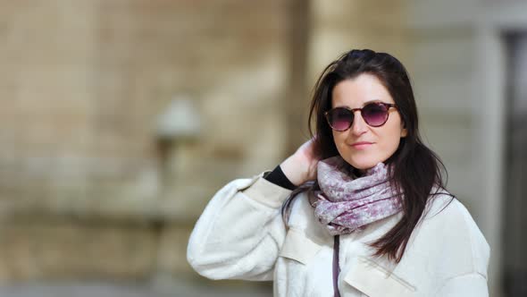 Portrait of Beautiful Smiling Brunette Woman in Sunglasses Posing Looking at Camera at Outdoor