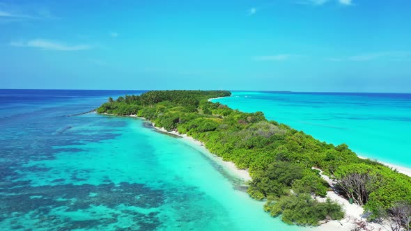 Wide aerial tourism shot of a sandy white paradise beach and blue sea background in high resolution 