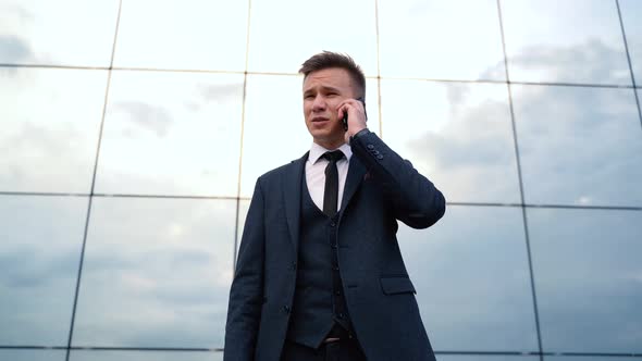 Desperate Young Businessman Get Bad News Heavy Problems Talking on Smartphone in City Outdoors