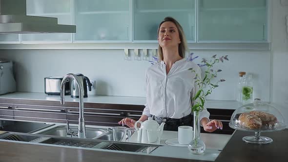 Beautiful Girl Stands in the Kitchen Looks Away