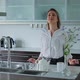 Beautiful Girl Stands in the Kitchen Looks Away - VideoHive Item for Sale