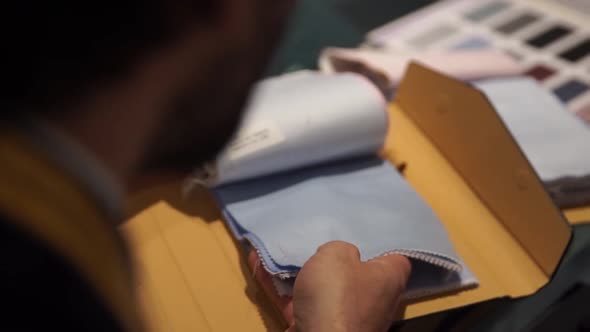 Crop tailor looking through cloth samples