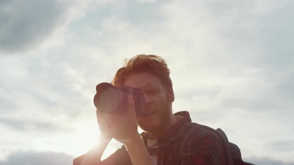 Photographing Hipster Enjoy Photo Shooting Camera on Wild Nature Sunrise