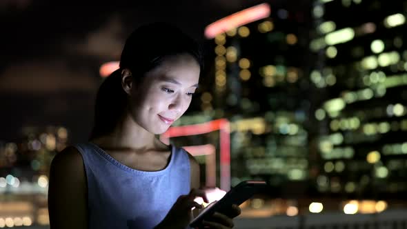 Woman using mobile phone in city 