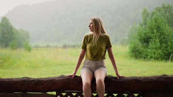 Thoughtful Lady Enjoys Nature Beauty Sitting on Log Fence