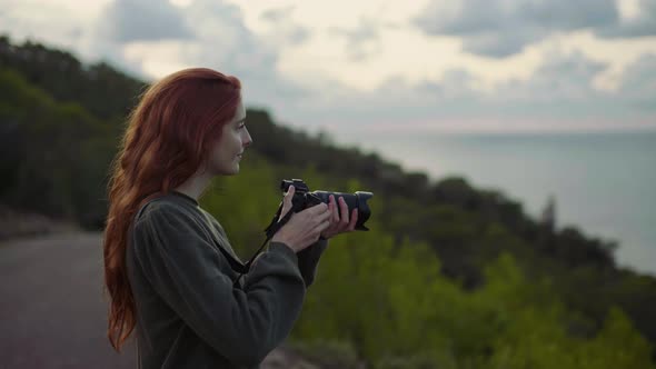 Female photographer photographing on viewpoint in the evening