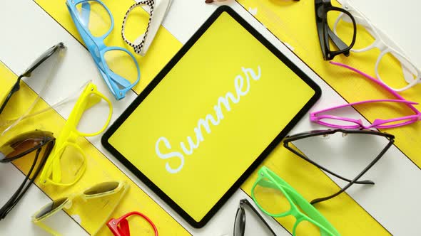 Various Style, Shape and Colour Sunglasses. Tablet in the Middle with Text SUMMER