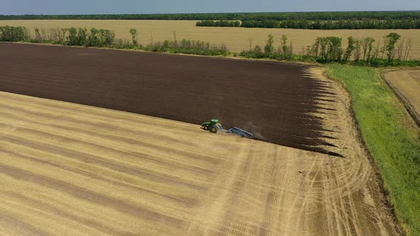 A Tractor Plows a Harvested Corn Field for Future Planting. View From Above