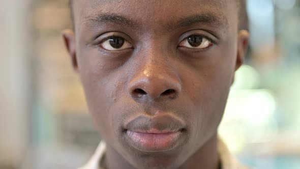 Close Up of Serious Young African Man Looking at Camera