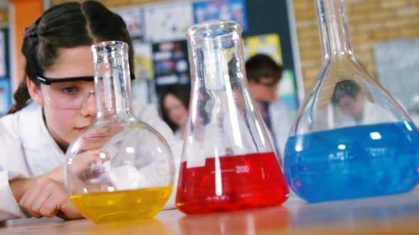Schoolgirl observing chemicals in laboratory