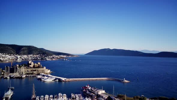 View from drone on full of yachts Bodrum harbour and ancient Kalesi castle in Mugla in Turkey