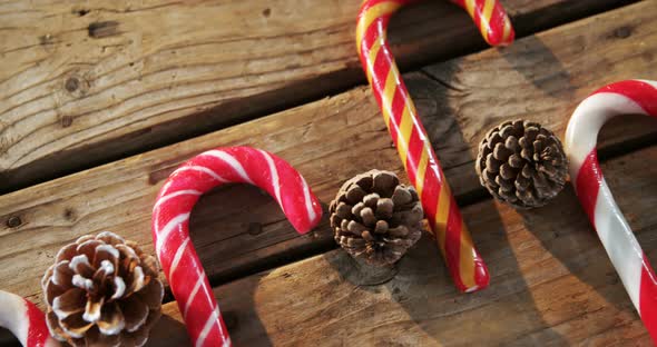 Candy cane with pine cone on wooden table 4k