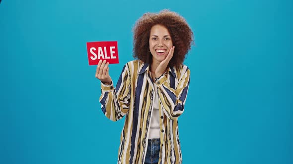 Cheerful Lady Holds Red Plate with Word Sale Smiling