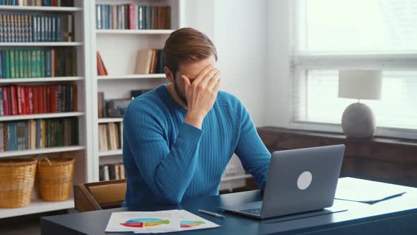 Upset young man at home office. Young male professional using computer