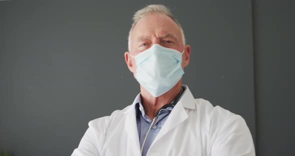 Portrait of caucasian senior male doctor wearing face mask