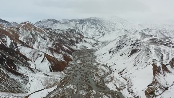 Drone Over Snow Covered Mountains Landscape With River