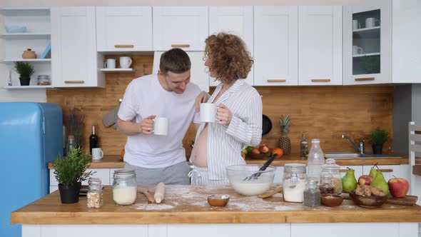 Happy Pregnant Couple Together In Kitchen