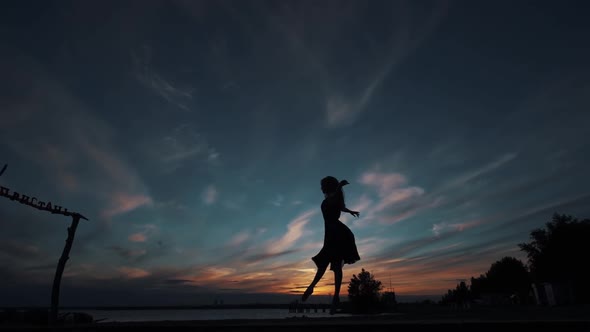 Silhouette of a Dancing Ballerina Against the Sunset Sky.