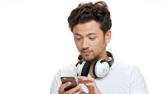 Young Handsome Man Smiling Listening Music in Headphones Dancing Over White Background