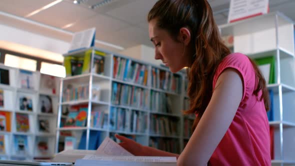 Schoolgirl reading books in library