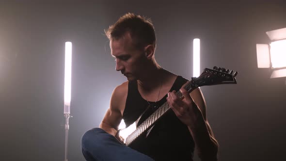 Cool Pumped-up Rock Guitarist in Black T-shirt Performs on Stage and Performs Solo Number on