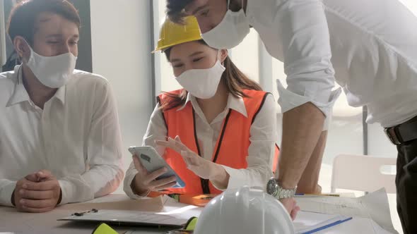 engineer caucasian male and asian female serious concentrate meeting with mask protection