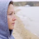 Sad Girl in Hoodie Stands on the Beach in Cloudy Weather - VideoHive Item for Sale