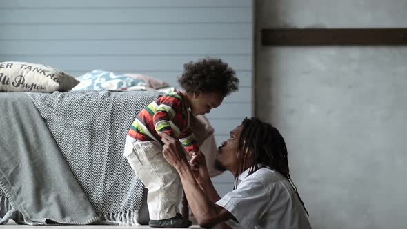 Playful Father Raising His Toddler Son Up in Air