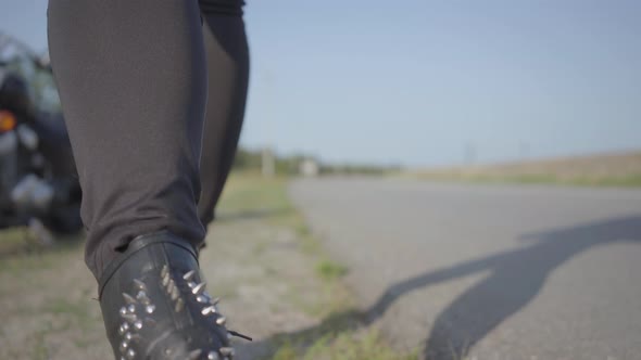 Unrecognizable Biker in Black Shoes Comes To the Motorcycle