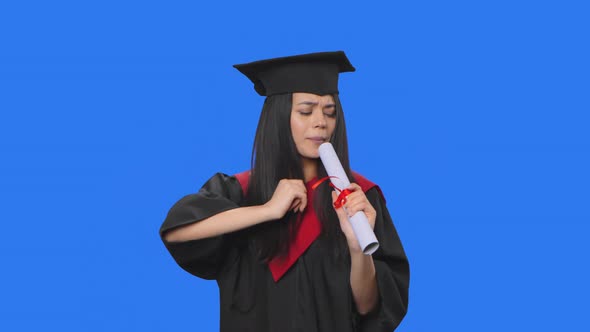 Portrait of Female Student in Graduation Costume Holding Diploma Dancing and Singing Merrily